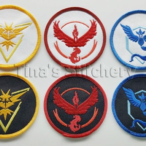 May include: Six round embroidered patches featuring the logos of the three legendary Pokemon birds: Articuno, Zapdos, and Moltres. Each logo is displayed on a white, black, or red background.
