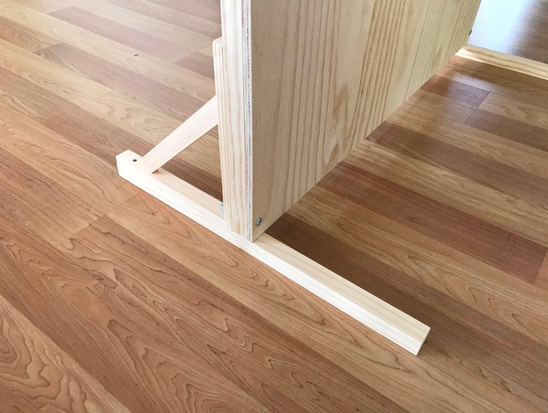 Puede incluir: Un soporte de madera con una estructura de soporte triangular y una base rectangular. El soporte est&aacute; hecho de madera de color claro y tiene un acabado natural.