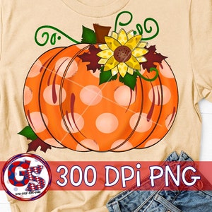May include: A beige t-shirt featuring a large orange pumpkin design with white polka dots. The pumpkin is adorned with a yellow sunflower, green leaves, and vines. The text "300 DPI PNG" is also visible.