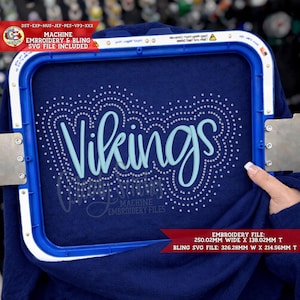 May include: A navy blue fabric is held in a blue embroidery hoop. The word "Vikings" is embroidered in light blue script, surrounded by a dotted design. The image includes text indicating machine embroidery and SVG file availability.