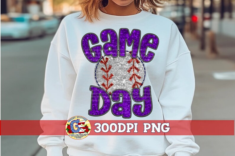 May include: White sweatshirt with a purple and silver glitter design that says "Game Day" with a baseball in the middle.