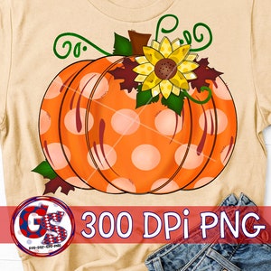 May include: A beige t-shirt featuring a large orange pumpkin with white polka dots, a yellow sunflower, and green vines. The text "300 DPI PNG" is displayed in the lower right corner. The design is perfect for fall and autumn-themed products.