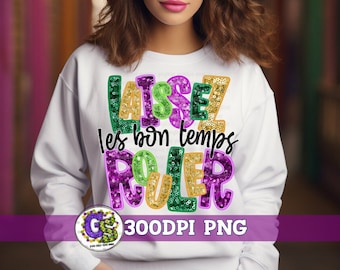 May include: White sweatshirt with a colorful graphic design that says "Laissez les bon temps rouler" in green, purple, gold, and orange sequins. The graphic is in a festive font and is perfect for Mardi Gras.