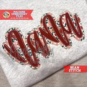 以下が含まれることがあります： 筆記体で「Nana」と刺繍されたグレーのTシャツ。文字は深い赤色で、花柄と白いステッチが施されています。画像には「Machine Embroidery Files」と「Bean Stitch」というテキストも含まれています。