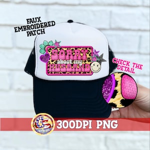 May include: A black and white trucker hat with a white front panel featuring a faux embroidered patch. The patch reads "Sorry about my husband" in pink bubble letters, with a leopard print background and decorative stars and hearts.
