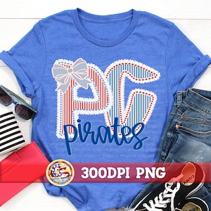 May include: Blue t-shirt with a graphic design featuring the letters "PG" in red and blue stripes, a bow, and the word "Pirates" in a script font. The shirt is paired with jeans, sunglasses, and a red wallet.