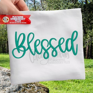 May include: White fabric with the word "Blessed" in teal script. The fabric is held up by a hand. The top left corner has a red banner with the text "MACHINE EMBROIDERY FILES".