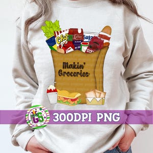 May include: A beige sweatshirt featuring a brown paper grocery bag graphic filled with groceries. The bag includes chips, coffee, sugar, and other items. The text "Makin' Groceries" is printed on the bag. A snow cone, sandwich, and fries are also shown.