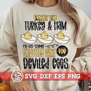 Puede incluir: Sudadera beige con el texto "FORGET THE TURKEY & HAM" y "I'D DO SOME SKETCHY SHIT FOR DEVILED EGGS". El diseño incluye ilustraciones de huevos rellenos. La parte inferior de la camisa tiene el texto "SVG DXF EPS PNG".