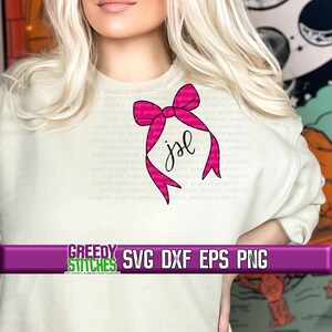 May include: A white sweatshirt with a pink bow and the initials "JSL" written in black cursive.