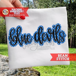May include: White fabric with the words "Blue Devils" in black script, outlined in blue with white polka dots. The words are machine embroidered. The words "Machine Embroidery Files" and "Bean Stitch" are also visible.