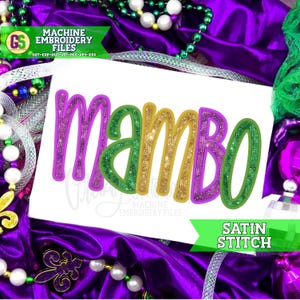 May include: A white card with the word "MAMBO" in large, glittery letters. The letters are outlined in purple, green, and gold. The card is surrounded by purple fabric, beads, and the text "MACHINE EMBROIDERY FILES" and "SATIN STITCH".