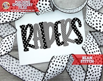 May include: Machine embroidery design file for "RAIDERS" in black and gray with white polka dots. The design is shown on a white fabric with black and white polka dot ribbon.