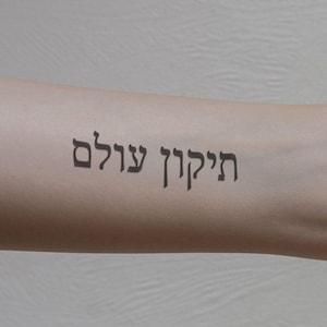 May include: A person's arm with a temporary tattoo that reads "הַכֹּל עֲבָר" in Hebrew.
