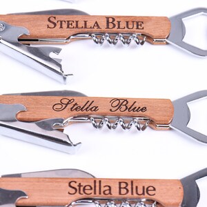 Puede incluir: Un abridor de botellas de madera con un sacacorchos y un abridor de botellas. El mango est&aacute; grabado con el nombre "Stella Blue".