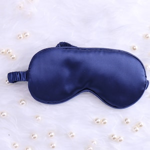 May include: A dark blue satin sleep mask for blocking out light.
