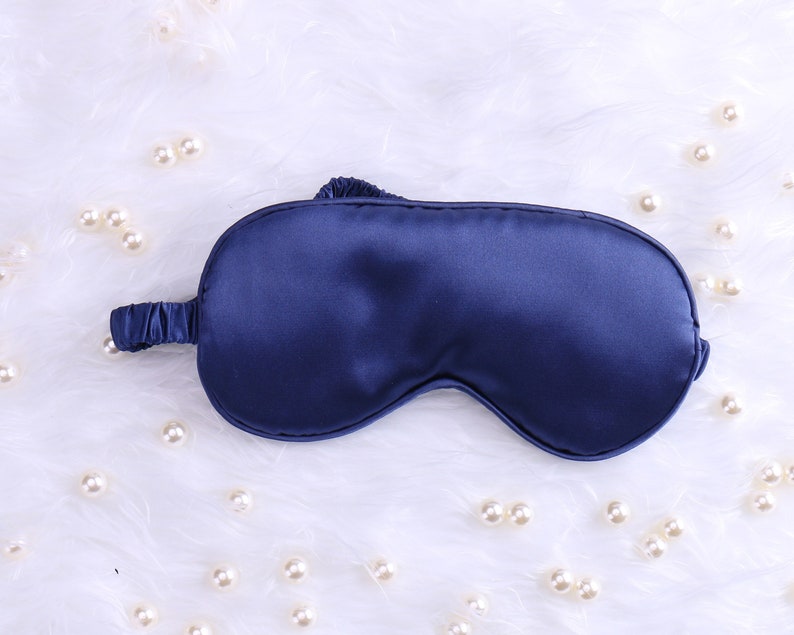 May include: A dark blue satin sleep mask for blocking out light.