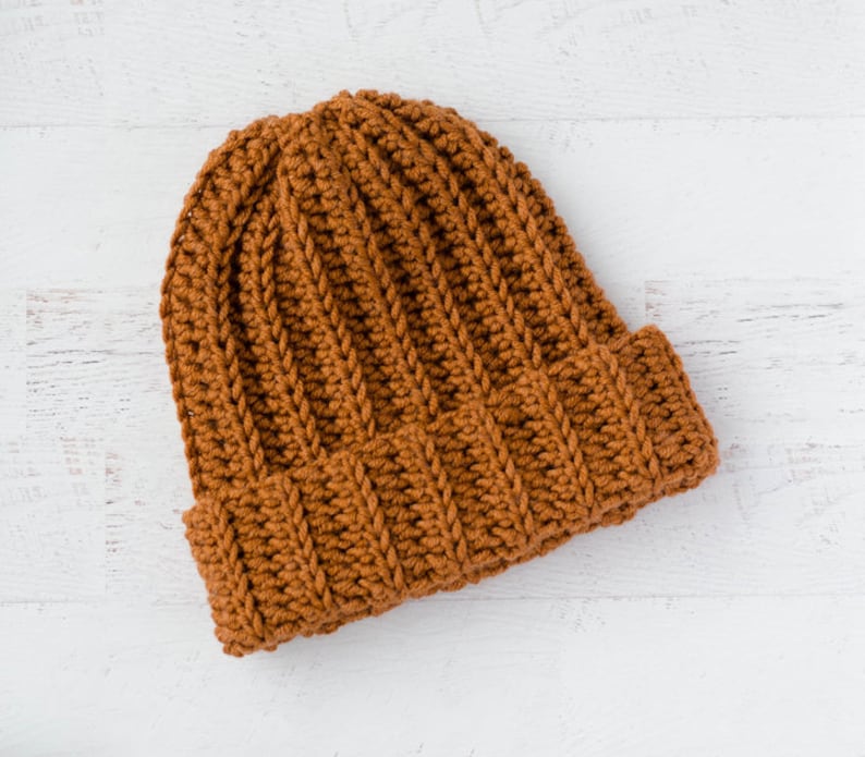 May include: A brown crocheted beanie hat with a ribbed texture.