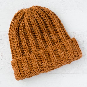 May include: A brown crocheted beanie hat with a ribbed texture.
