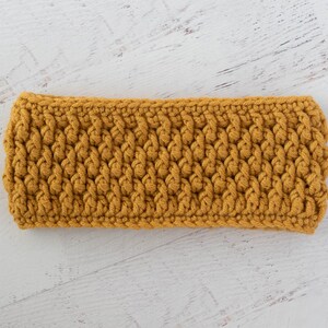 Peut inclure: Bandeau en crochet jaune moutarde. Le bandeau est fait de fil &eacute;pais et pr&eacute;sente un motif textur&eacute; et tiss&eacute;. L'accessoire est con&ccedil;u pour garder les oreilles au chaud et convient aux climats froids.