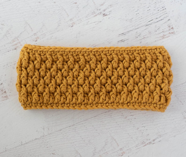 Peut inclure: Bandeau en crochet jaune moutarde. Le bandeau est fait de fil &eacute;pais et pr&eacute;sente un motif textur&eacute; et tiss&eacute;. L'accessoire est con&ccedil;u pour garder les oreilles au chaud et convient aux climats froids.