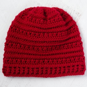 May include: A red crocheted beanie hat with a ribbed texture.