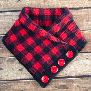 May include: A red and black plaid crocheted cowl with red buttons.