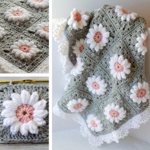 May include: A crocheted baby blanket with a white daisy pattern on a sage green background. The blanket has a white crocheted border.