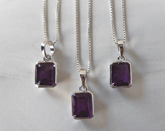 May include: Three silver necklaces with square-shaped amethyst pendants. The pendants are a deep purple color.