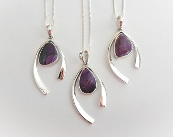 May include: Three silver necklaces with purple stone pendants. Each pendant is a teardrop shape with a silver frame. The necklaces are on a white background.