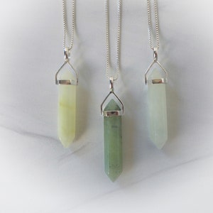 May include: Three silver necklaces with green and white crystal point pendants. The pendants are all in the shape of a point, with a silver cap at the top.