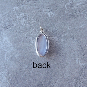 K&ouml;nnte beinhalten: Die R&uuml;ckseite eines silbernen Anh&auml;ngers mit einem hellblauen ovalen Stein. Der Anh&auml;nger hat eine &Ouml;se zum Anbringen einer Kette. Der Text "back" ist unter dem Anh&auml;nger gedruckt.