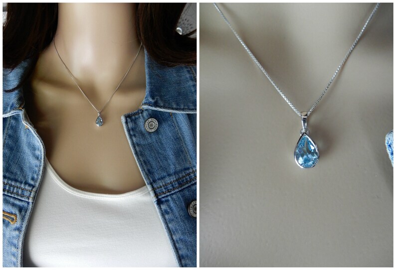 May include: A silver chain necklace with a teardrop-shaped blue topaz pendant.