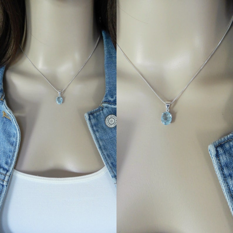 May include: A silver chain necklace with a light blue gemstone pendant.