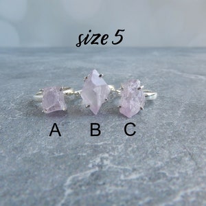 K&ouml;nnte beinhalten: Drei Silberringe mit rosafarbenen Kristallsteinen. Die Ringe sind mit A, B und C beschriftet. Der Text "Gr&ouml;&szlig;e 5" befindet sich &uuml;ber den Ringen.