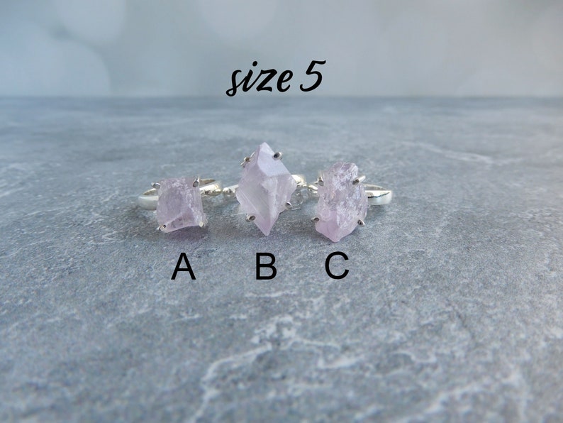 K&ouml;nnte beinhalten: Drei Silberringe mit rosafarbenen Kristallsteinen. Die Ringe sind mit A, B und C beschriftet. Der Text "Gr&ouml;&szlig;e 5" befindet sich &uuml;ber den Ringen.
