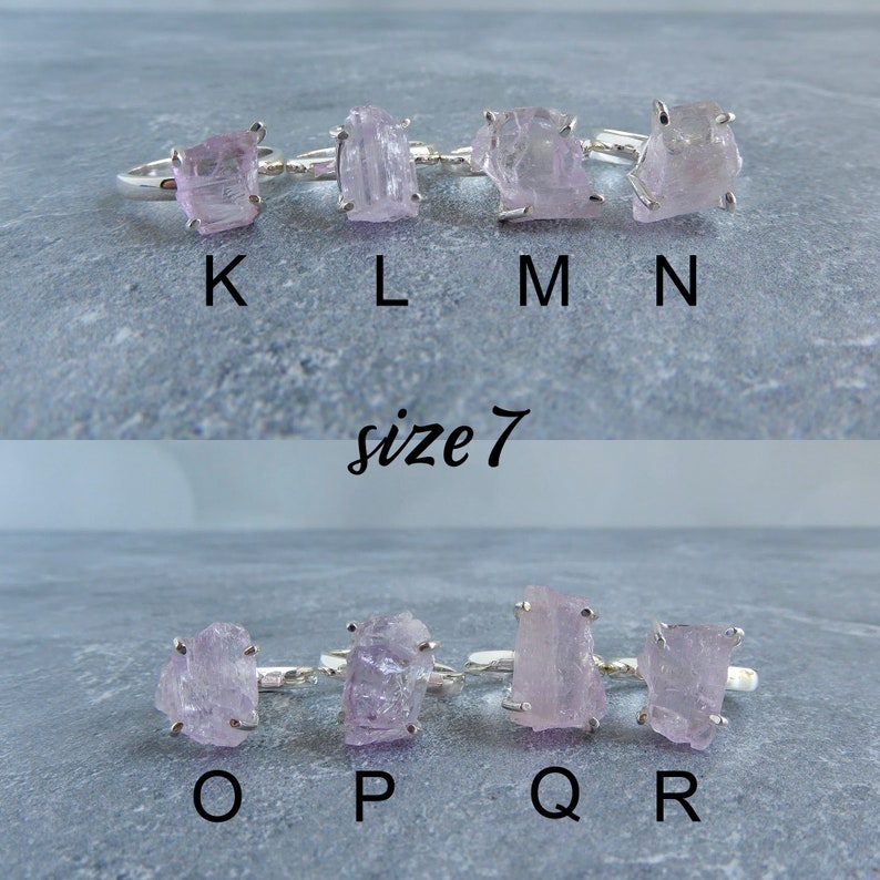 K&ouml;nnte beinhalten: Acht Silberringe mit rosafarbenen Kristallsteinen. Die Ringe sind mit K, L, M, N, O, P, Q und R beschriftet. Die Ringe sind Gr&ouml;&szlig;e 7.