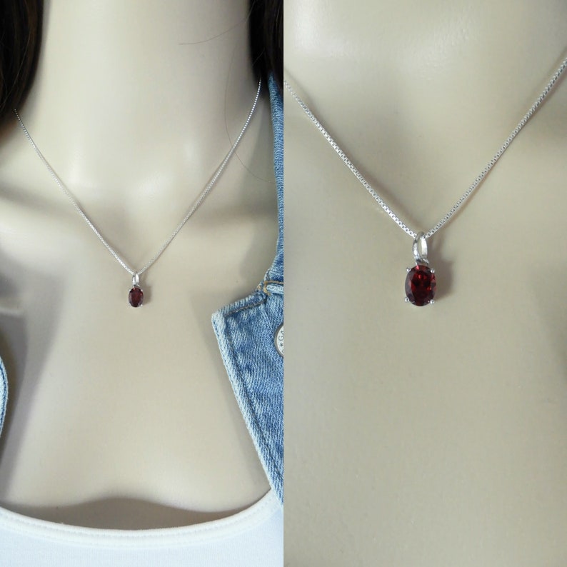 Pu&ograve; includere: Una collana con catena d'argento con un piccolo ciondolo di forma ovale con una pietra rossa.