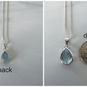 May include: A teardrop-shaped pendant necklace with a light blue gemstone. The pendant is about the size of a dime.