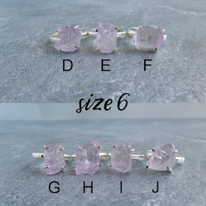 K&ouml;nnte beinhalten: Zehn Silberringe mit rosafarbenen Kristallsteinen. Die Ringe sind mit den Buchstaben D, E, F, G, H, I und J beschriftet. Die Ringe sind Gr&ouml;&szlig;e 6.