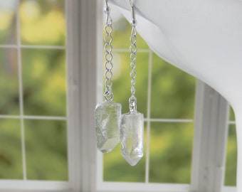 Puede incluir: Pendientes de plata con gotas de cristal de cuarzo transparente. Los cristales son facetados y tienen un aspecto natural y en bruto.