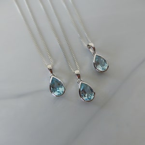 May include: Four silver necklaces with teardrop-shaped blue topaz pendants.