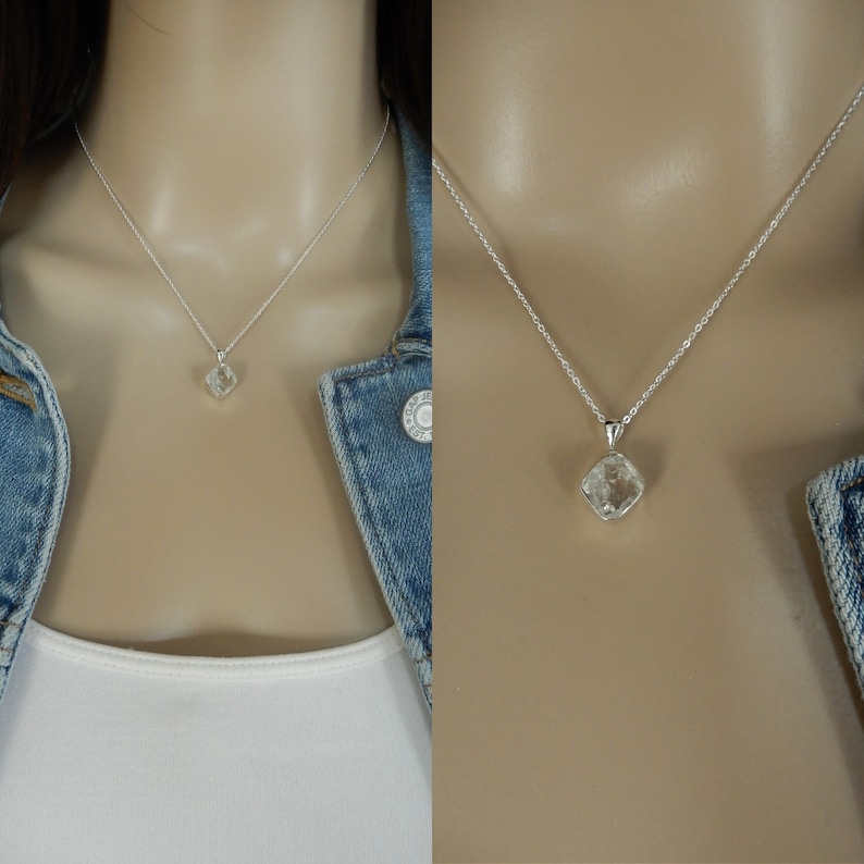 May include: A silver chain necklace with a clear, faceted, square-shaped crystal pendant.