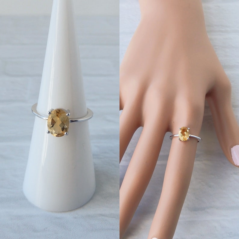 Peut inclure: Une bague en argent avec une pierre ovale brun clair. La bague est sur un pr&eacute;sentoir blanc et sur le doigt d'un mannequin.