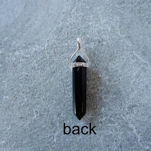 May include: Black obsidian crystal point pendant with a silver bail. The bail is marked with "925" for sterling silver. The back of the pendant is shown in the image.