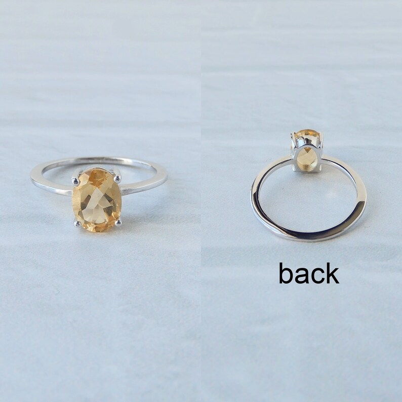 Peut inclure: Une bague en argent avec une pierre ovale jaune clair. La bague est pr&eacute;sent&eacute;e de face et de dos.