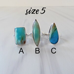 May include: Three silver rings with different shaped turquoise stones. The rings are labeled A, B, and C. The text "size 5" is written above the rings.