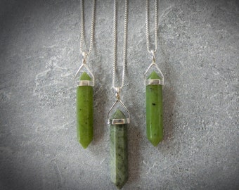 May include: Three silver necklaces with green jade stone pendants in the shape of a point. The pendants are all the same size and shape, but the chains are different lengths.