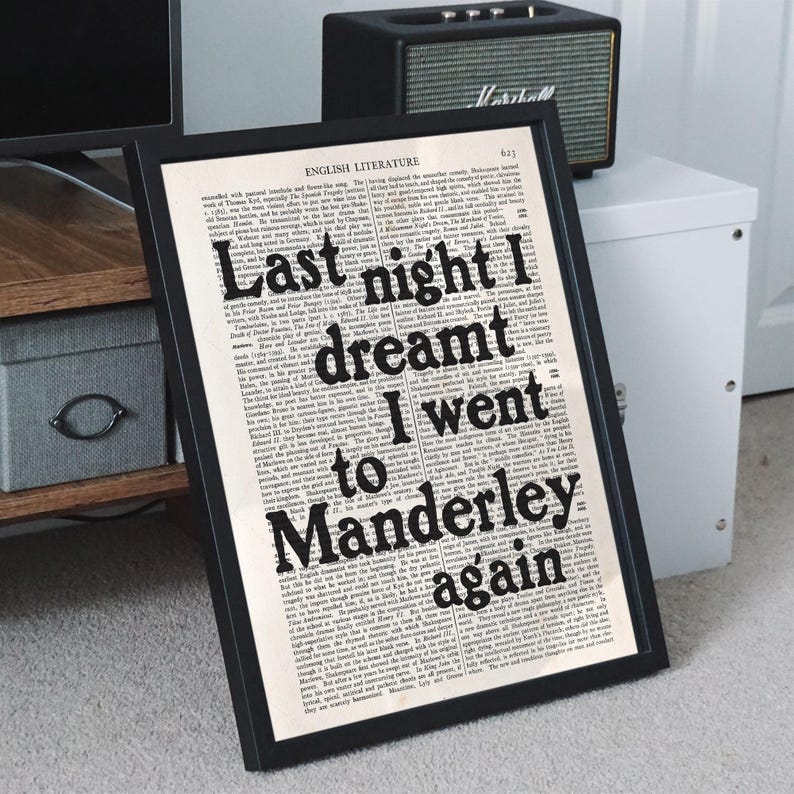 May include: A black framed print with a white background and black text. The text reads "Last night I dreamt I went to Manderley again".