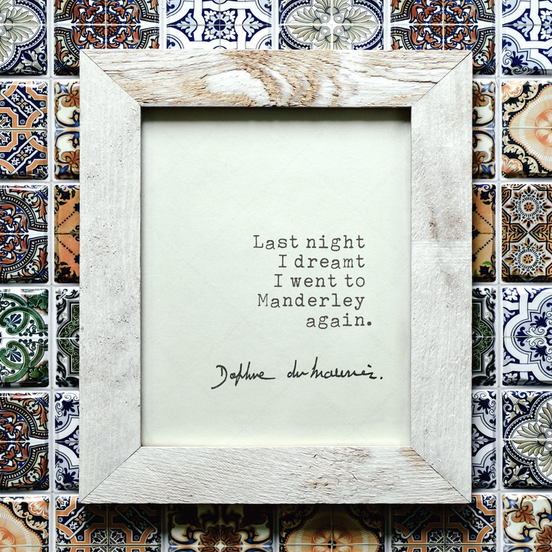Może przedstawiać: Biała drewniana ramka z białym tłem i czarnym tekstem, kt&oacute;ry brzmi "Last night I dreamt I went to Manderley again." Tekst jest podpisany "Daphne du Maurier".